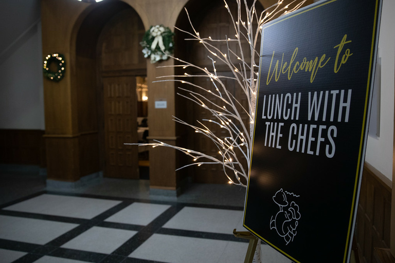 Entrance to the IMU Main Lounge, a Lunch with the Chefs poster is displayed on an easel outside the side entrance