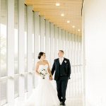 Bride and groom standing by window and looking at one another